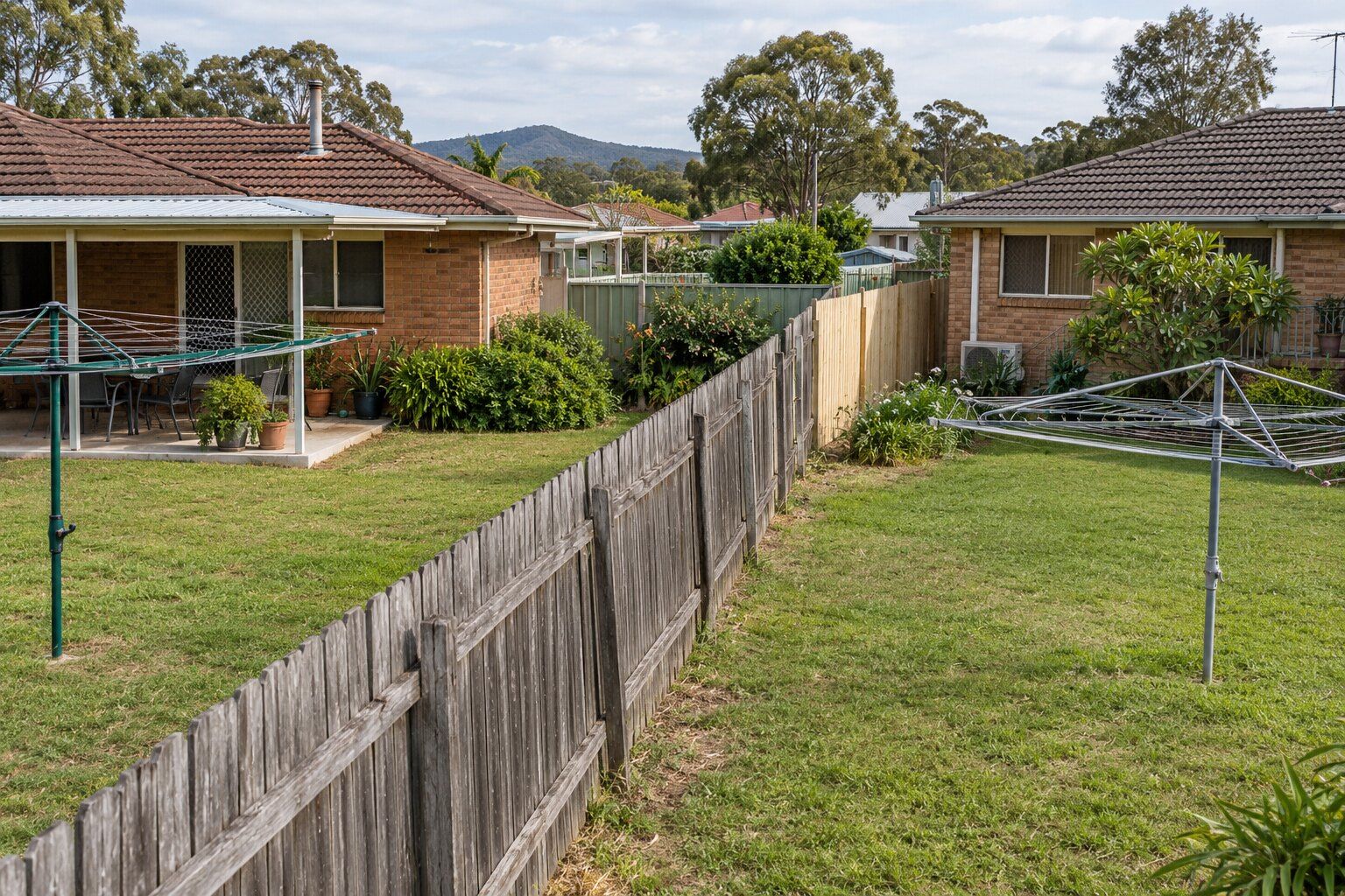 Fencing guides, Maitland: an old timber paling dividing fence between two backyards with a new section started